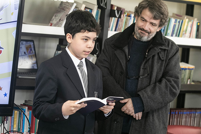 Niño de pie leyendo libro